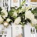 Dining tables were decorated with ivory roses accented with greenery, with simple black and white menus at each setting. "I had designed the menus to sit on top of a folded napkin, tied with twine, a name tag and a lavender sprig," Christine says.