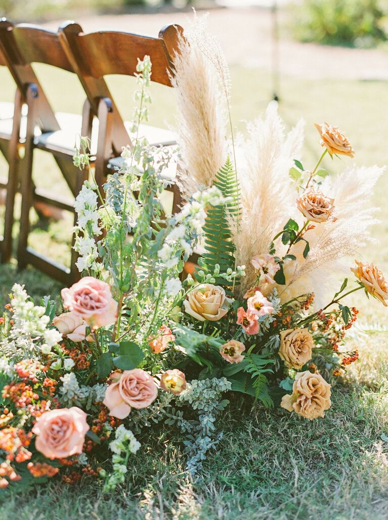 Aisle floral arrangements with roses, ferns and pampas grass