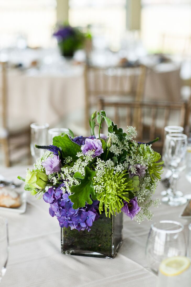 After choosing the flowers for the day, Lauren and Richard chose a navy, purple and green color palette. Their florist, Antheia Floral Design, created the unique centerpieces using purple and green chrysanthemums, hydrangeas, roses and Queen Anne's lace in square glass vases.