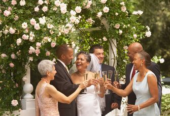 Couple toasting champagne flutes with guests