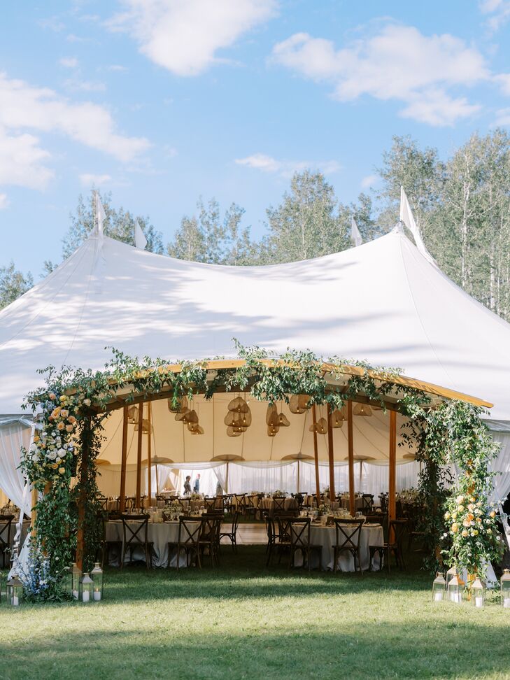 Wooden Arch in at Entrance of Tented Reception Adorned With Greenery