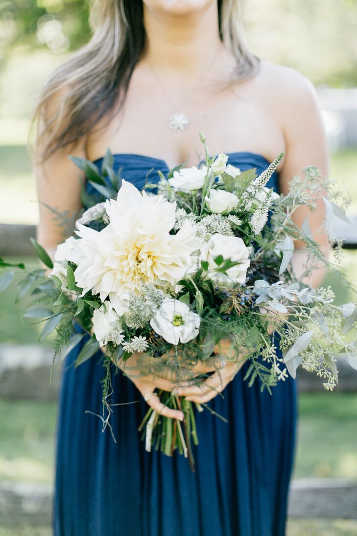 Pops of white blooms, like dahlias, filled the whimsical bridesmaid bouquets that offset the dark navy of their dresses.