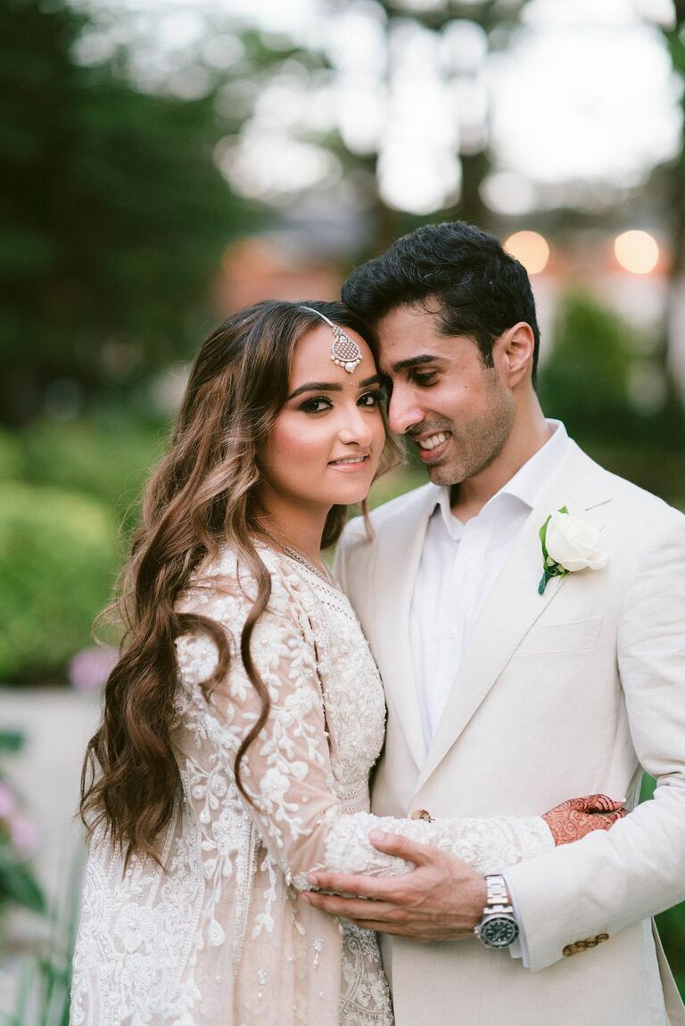 Couple hugging and wearing all-white wedding fashion