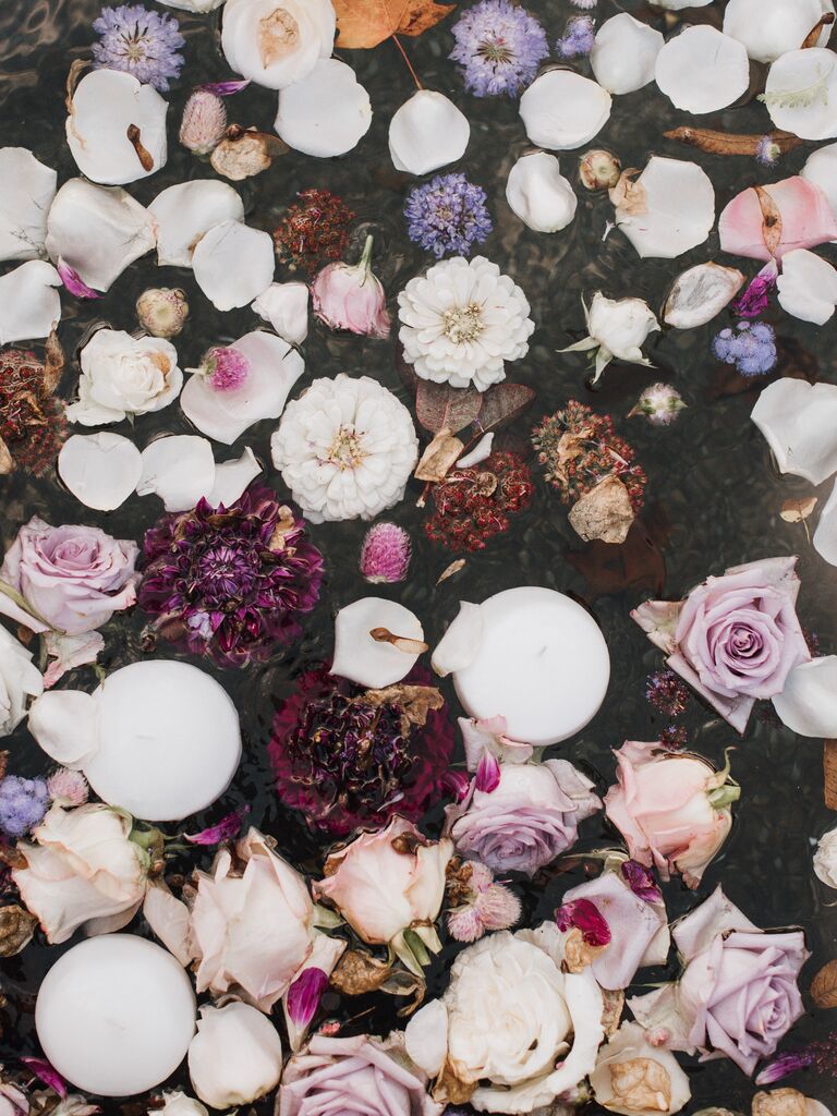 overhead view of dark purple, burgundy and white flowers in water 