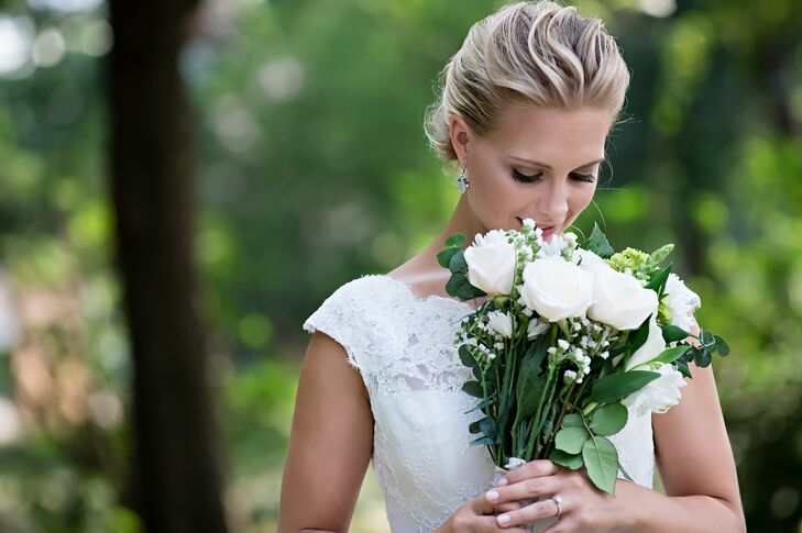 Laura's classic wedding style was complete with a sophisticated wavy updo and a small, chic bouquet of long stem white roses. She paired this with her grandmother's earrings (something borrowed) and an old baby blanket sewed into her bouquet (something old).