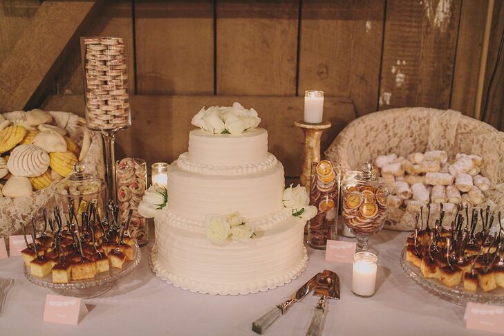 The couple opted for a traditional, three-tiered, white, round wedding cake and topped it with fresh white roses.