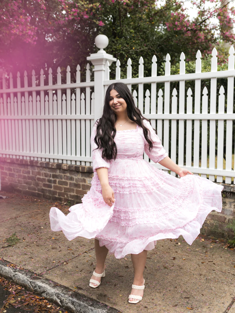 A model twirls, showing off this lovely floral gown.