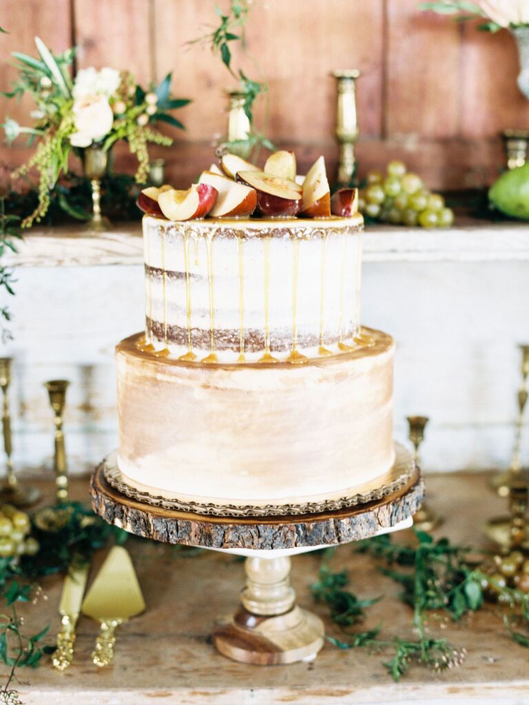 Two-tier rustic cake with apple slices and caramel drizzle on top
