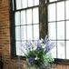 The DIY escort cards were displayed on a vintage brown table next to a lush floral arrangement and candle votives.