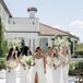 Bride and Groom Under String Lights Lifted Up in Chairs During Reception