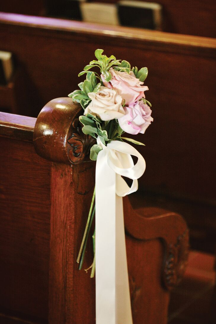 Bunches of roses and various greens embellished the ends of the ceremony pews.