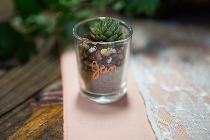 The bride made each guest an escort card that doubled as a wedding favor; she wrote each name on a small candle holder filled with river pebbles and sand from the property and topped each with a miniature succulent.