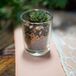 The bride made each guest an escort card that doubled as a wedding favor; she wrote each name on a small candle holder filled with river pebbles and sand from the property and topped each with a miniature succulent.