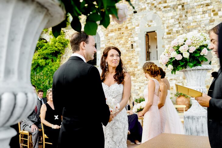 Surrounded by 55 of their closest family members and friends, Lindsay and Robert exchanged vows in an intimate outdoor ceremony at Castello di Vincigliata in Tuscany. Two stone urns overflowing with blush roses and hydrangeas framed the pair as they stood against a backdrop of rolling hills and lush greenery.
