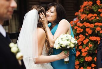 A bride and her mother sharing a hug on the wedding day