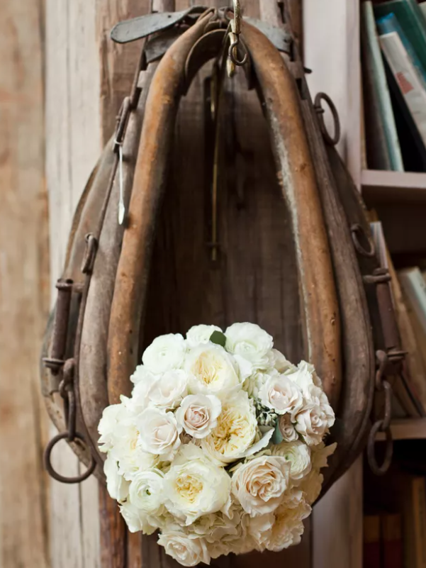 Western horse saddle holds a bouquet of beautiful white roses. 