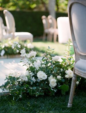 White Flower Arrangements With Greenery Lining the Ceremony Aisle