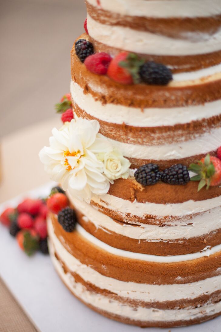The naturalistic, rough-frosted wedding cake from Krumbs Bakery in San Rafael, California, was topped with fresh blossoms and berries.
