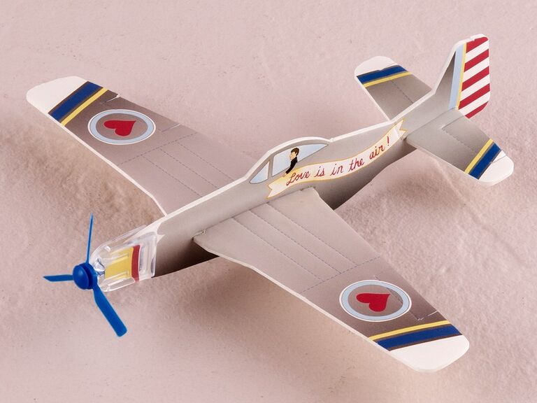 Cute toy airplane party favors with a banner on the side that reads "Love is in the air." 