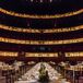 To go with the dramatic performance hall, Millie and Luke had a center head with 50 guests, surrounded by smaller round tables. The tables were covered with light pink cloths,  runners of seeded eucalyptus and elegant gold accents. Every seat included a menu what was at the dinner stations.