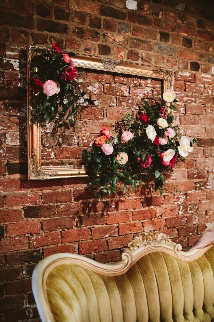 Elegant Wood Frame and Flower Arrangements on Brick Wall