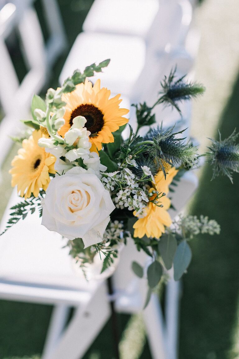 Ceremony aisle markers with thistles, white roses and sunflowers