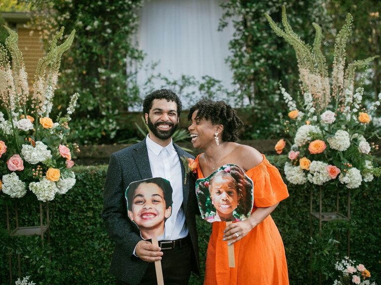 Couple laughing and holding baby picture cutouts
