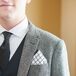 Tyler wore a suit jacket with a gray and white pattern, matched by black-and-white accessories, such as a black tie and a black-and-white-checkered pocket square.