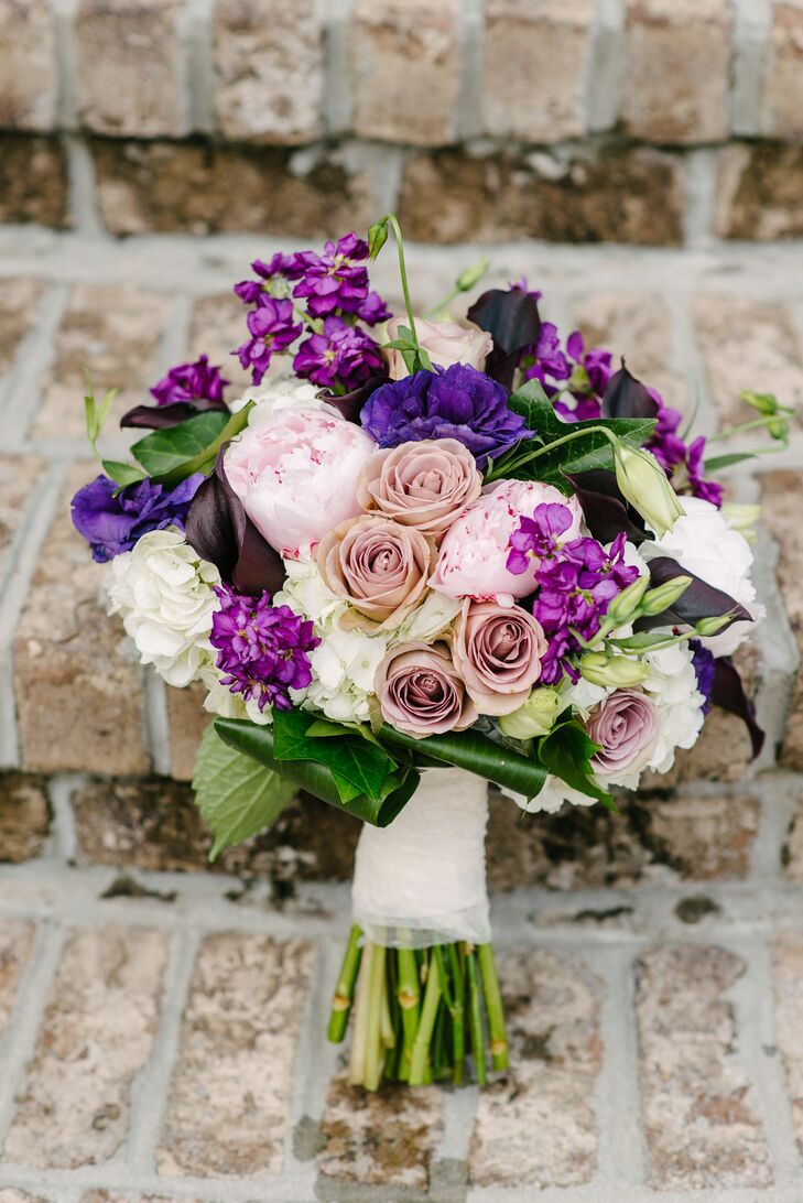 Elizabeth carried pink peonies, white hydrangeas, purple lisianthus and purple sweet peas in her bold bouquet. She loved how it added a pop of color to her simple Stella York ball gown wedding dress.