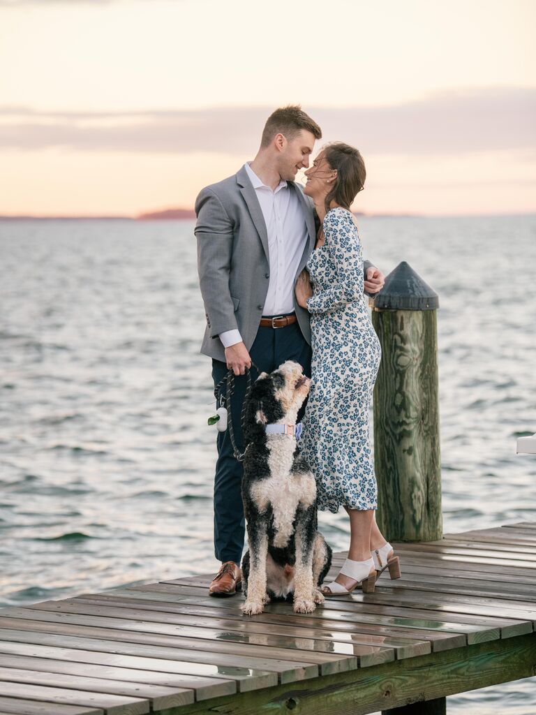 Couple smiling while standing on a pier.