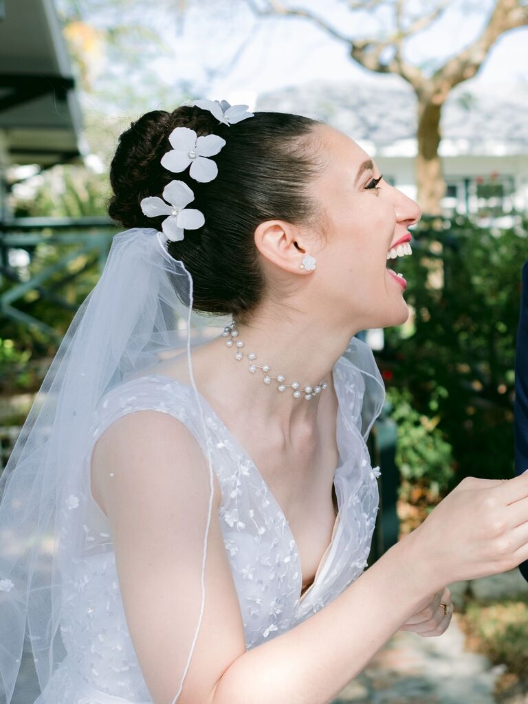 beach wedding hairstyles topknot with veil underneath and flowers