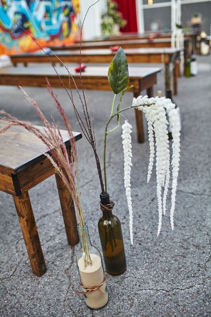 The aisle was lined with wine bottles that Angela and Cameron had saved over the years, and they decorated them with lace and leather and filled them with dried flowers.