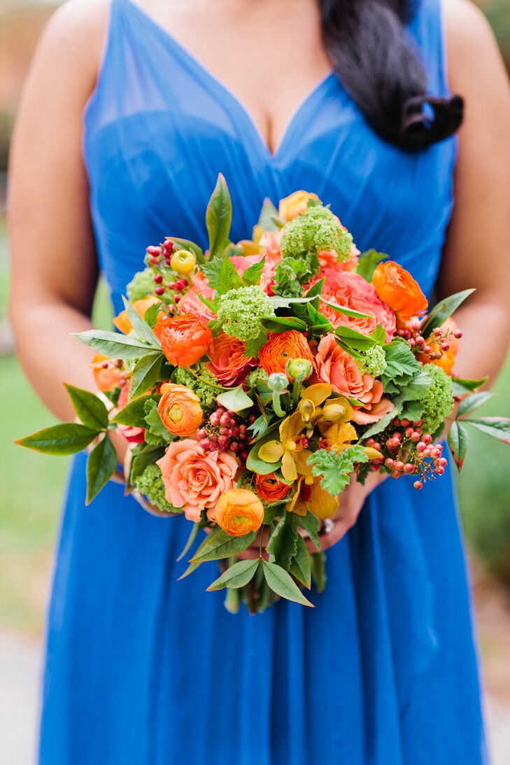 Amanda’s two bridesmaids donned vibrant cobalt blue gowns and carried a bouquet of cheery orange blooms.