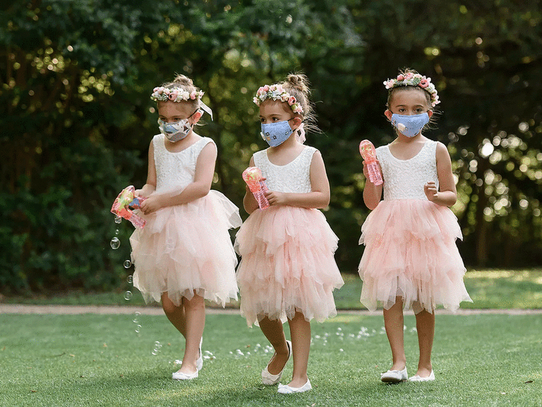 Three Flower Girls Walking Down the Aisle With Bubble Makers.