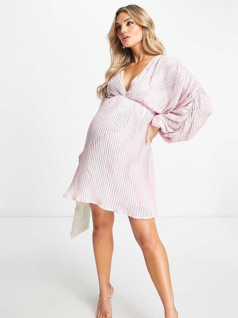 Model wears a blush pink pleated dress. 