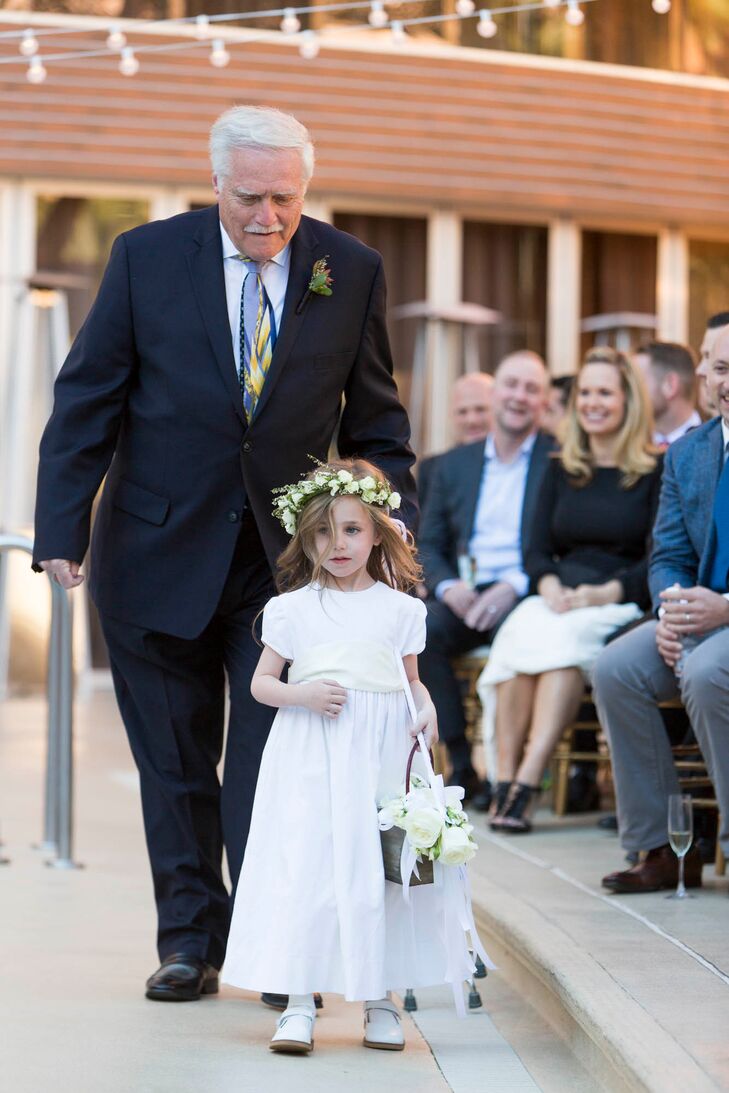 The fathers of the grooms escorted the children down the aisle. Both wore white attire from Bailey Boys Classic Collection in contrast to their fathers' dark suits.