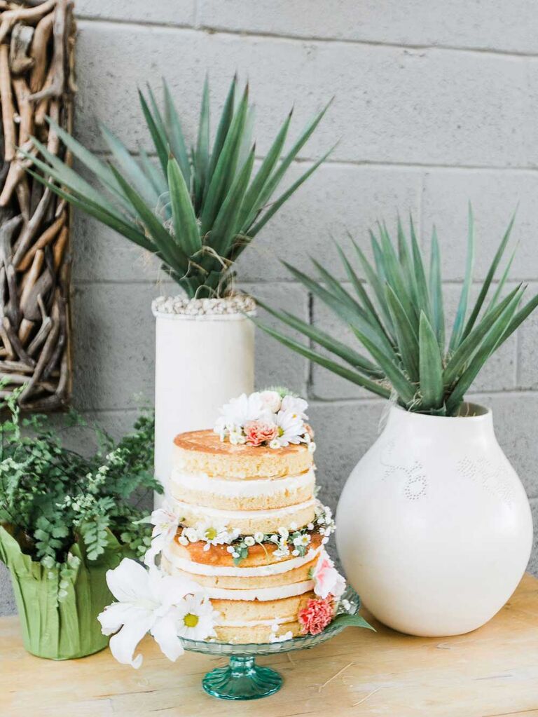 Small naked wedding cake with fresh flowers
