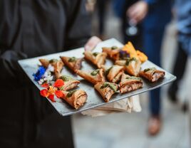 sever holding mini samosas on tray