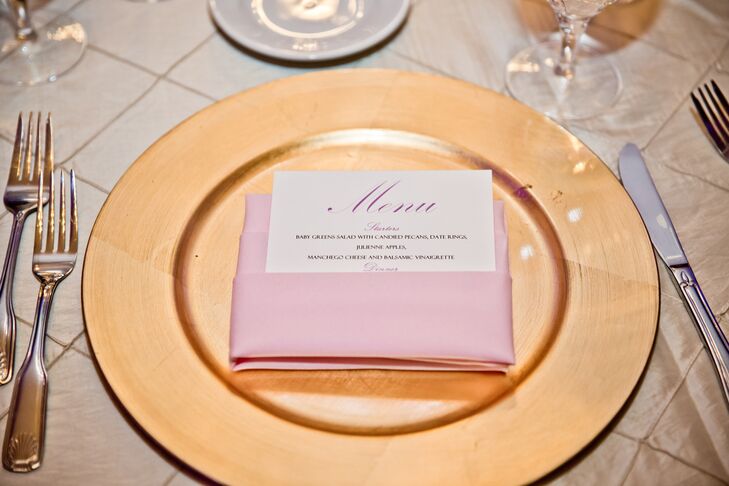 At the reception, dining tables were dressed in champagne-colored tablecloths and set with menu cards folded into pink napkins and placed on top of gold plates.