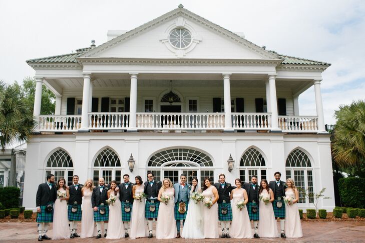 Nina's nine bridesmaids wore the same Monique Lhuillier one-shoulder blush tulle gown. Nina loved the soft, romantic look and style and how it flattered all the special ladies in her life. The groomsmen wore the Flower of Scotland kilts with gray tweed waistcoats, jackets and sporrans (small pouches worn around the waist) completed with teal bow ties.
