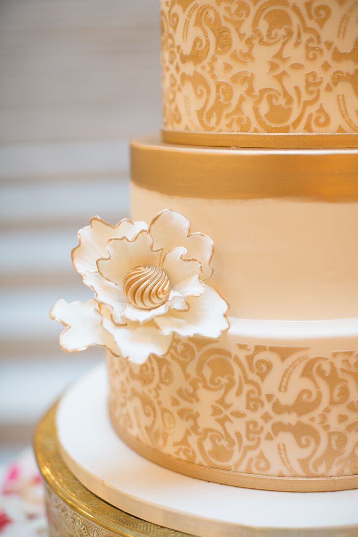 Emily and Tyler's venue, the Rookery in Chicago, Illinois, inspired their cake design—a gold and white confection covered in fondant and topped with white sugar flowers.