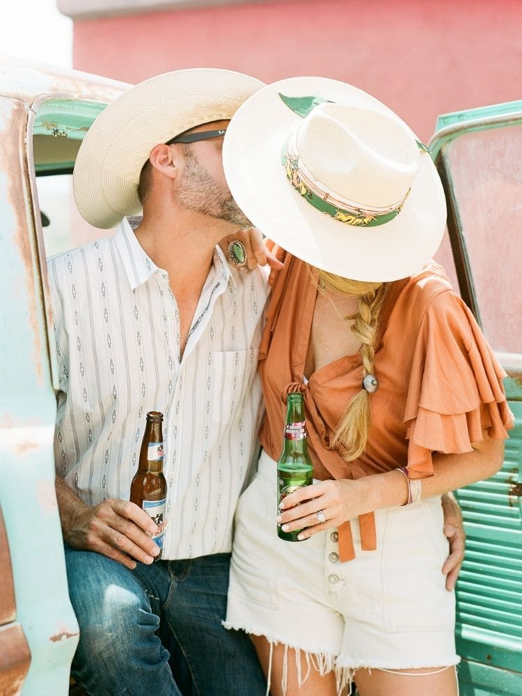 couple wearing cowboy hats and kissing