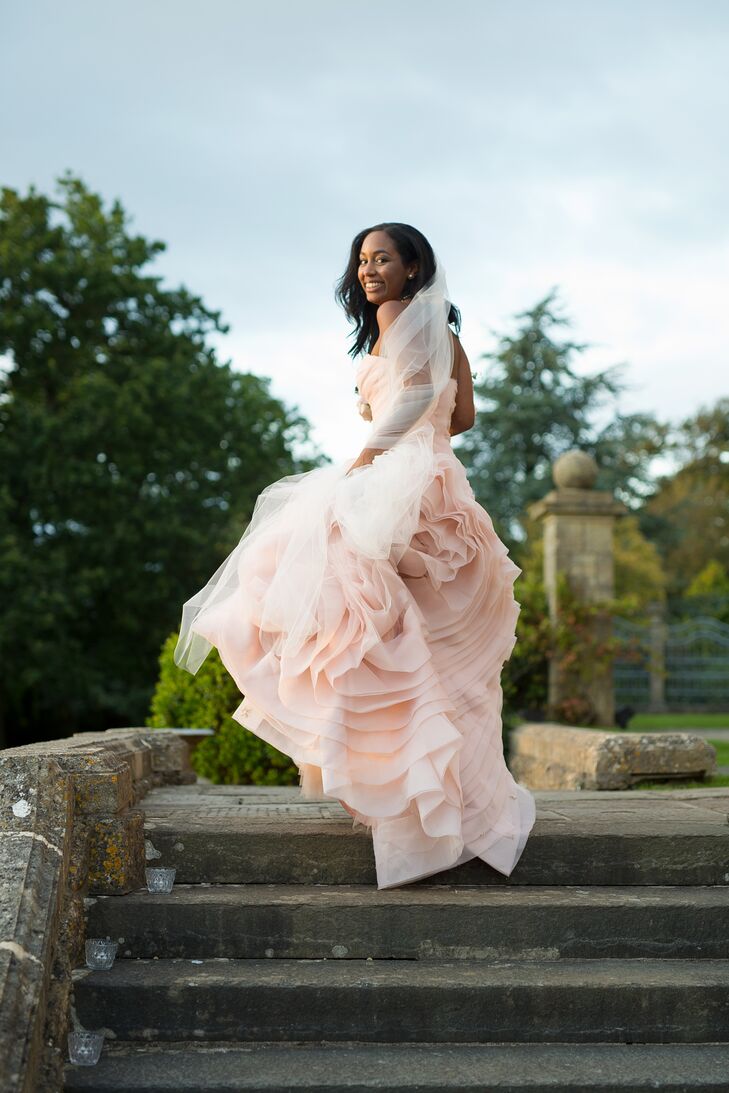 “I never really envisioned myself in a white dress,” Claudette says. “I liked the idea of blush, and when I saw the Vera dress on the hanger, I had to try it on. It was between that dress and an ivory one in another store. I went home and couldn’t stop thinking about the blush dress. So I went back, tried it on again and cried!” The dropped-waist gown was the perfect fit for the elegant estate affair, with its whimsical textured skirt, pleated organza and soft, pink hue.