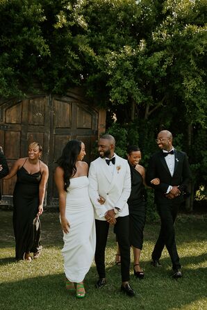 Bride in Simple, Modern, Sleek Gown With Groom in White Tux Jacket and Wedding Party in Black
