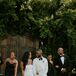 Bride in Simple, Modern, Sleek Gown With Groom in White Tux Jacket and Wedding Party in Black