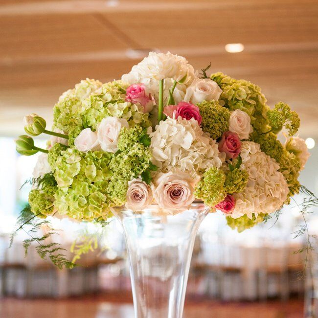 At the reception there were high floral arrangements displayed in crystal vases. The arrangements were made up of roses, hydrangeas, and viburnum.