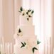 Glamorous Round Tiered Buttercream Cake with White Flowers on Gold Cake Stand
