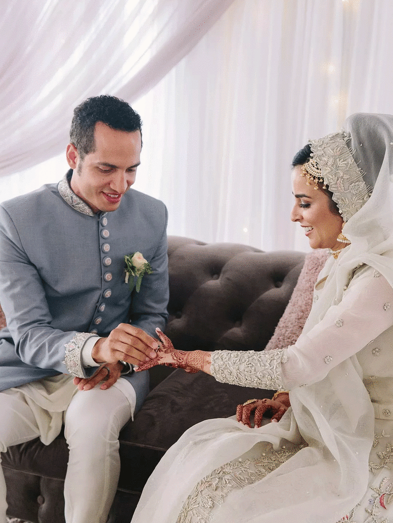 Elegant bride and groom during Muslim ring exchange tradition.