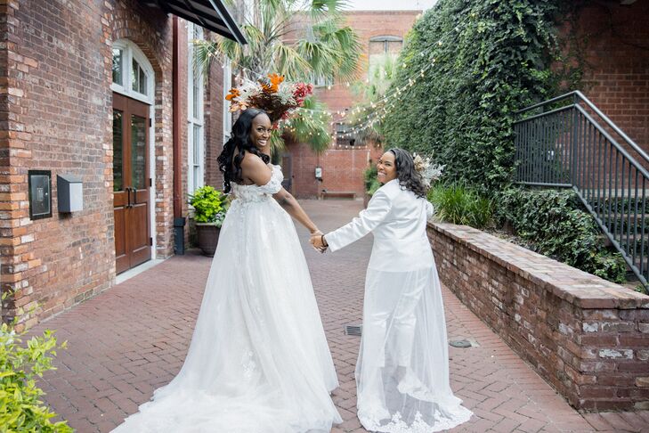 Two Brides in Romantic White Ensembles, One Dress and One Pantsuit, Holding Hands