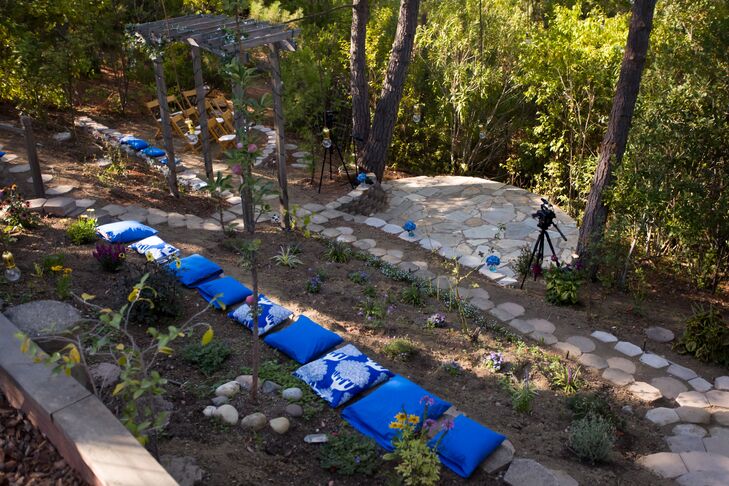 The ceremony and reception took place in Aly's mother's backyard in Martinez, California. The theme was secret garden, with natural elements filling the space, twinkling lights strung from above and accents of blue seen everywhere guests turn. Aly made bright blue pillows lined up in rows for guests to sit on during the celebration.